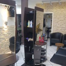 Arbeitsbereich Friseursalon mit Spiegeln und dunklen Friseurstühlen 